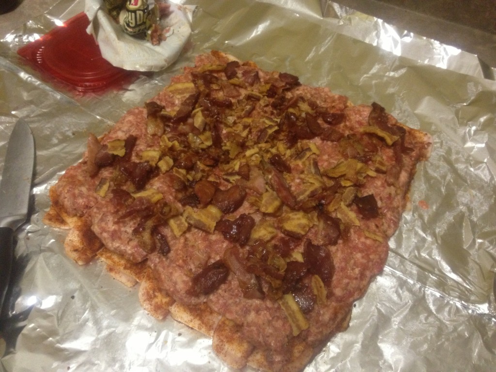 Next, sprinkle the crumbled baked bacon across the bulk sausage.